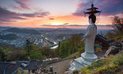 A statue towers over a buddhist temple in South Korea, a new destination Contiki offered in 2024.