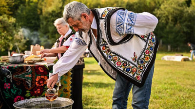 A man in folkloric costume cooks traditional food outdoors in Neamt County, Romania. Romania will become part of Europe's Schengen Area in January.